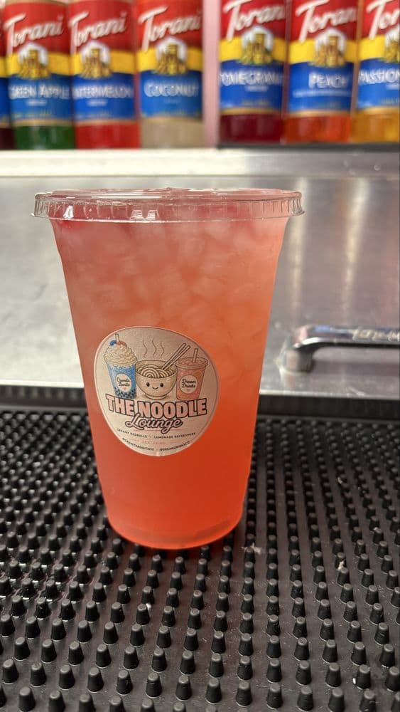 Strawberry lemonade refresher in front of the Torani syrup wall